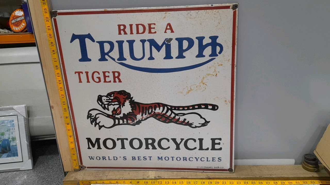 Lot 43 - RIDE A TRIUMPH TIGER MOTORCYCLE ENAMEL SIGN   23" X 23"