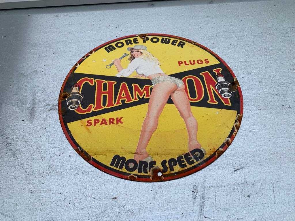 Lot 165 - CHAMPION SPARK PLUGS , MORE SPEED ENAMEL SIGN  12" DIA