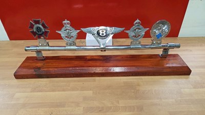 Lot 209 - 5 VINTAGE CAR BADGES ON DARK WOOD BASE